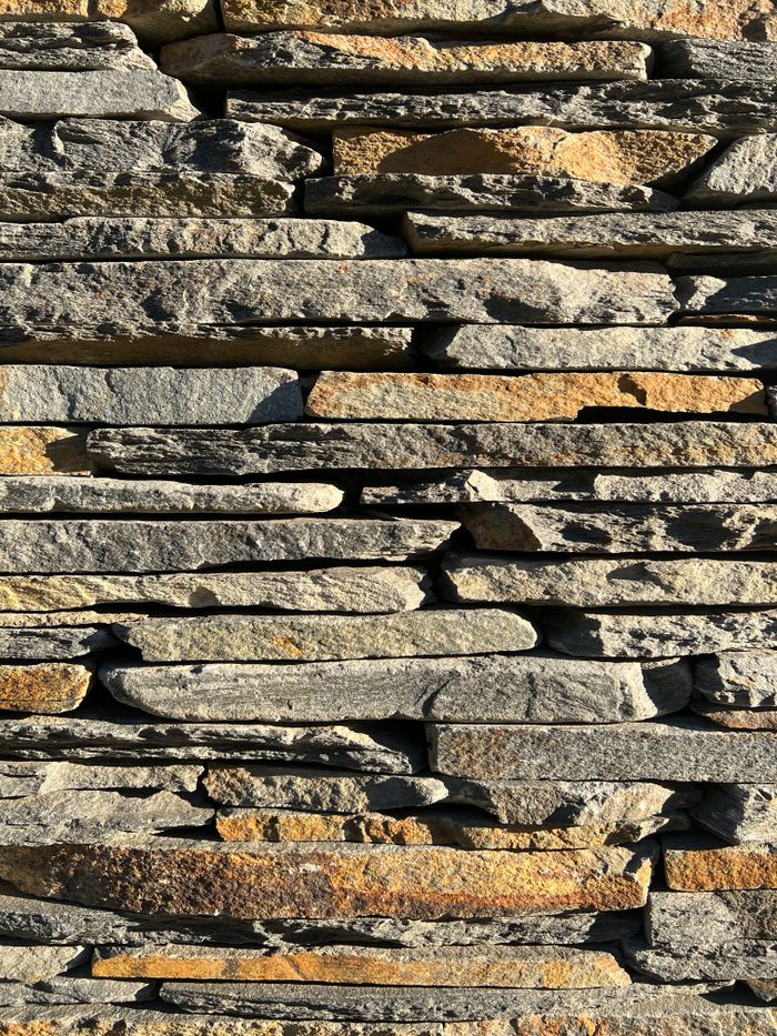 Crafting Captivating Headlines: Your awesome post title goes here Close-up of a natural stone wall showcasing varied patterns and textures in bright sunlight.